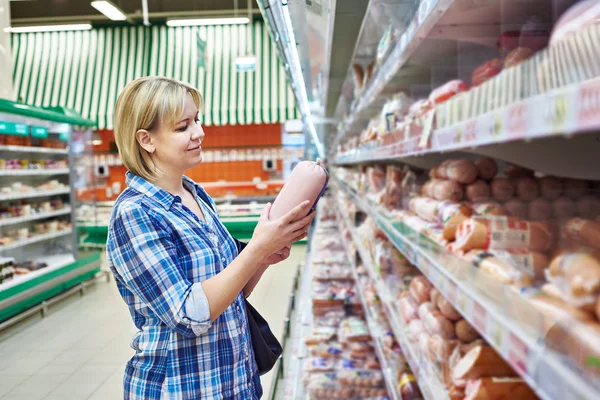 Vrouw koopt gekookte worst in supermarkt — Stockfoto