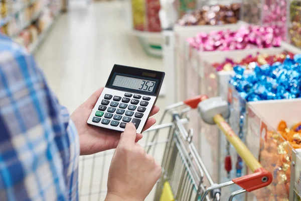 Femme au foyer considère les coûts en magasin — Photo