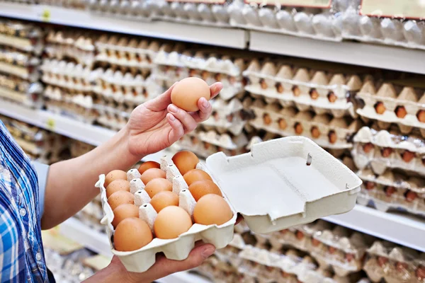 Em mãos de mulher que empacota ovos no supermercado Imagens De Bancos De Imagens Sem Royalties