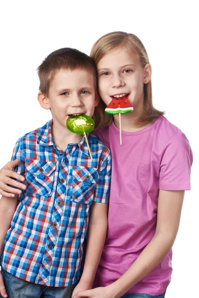 Girl and boy eating a lollipops — Stock Photo, Image