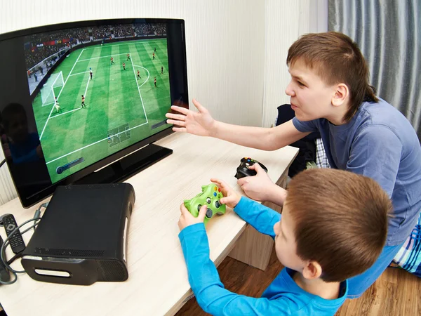 Enfants jouant sur la console de jeux pour jouer au football — Photo