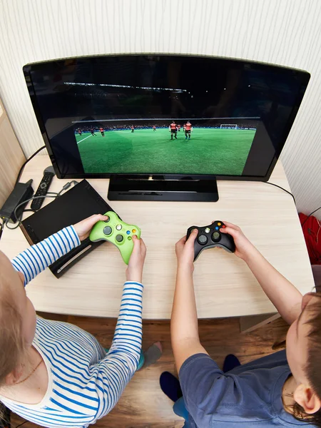 Children playing on games console to play football — Stock Photo, Image