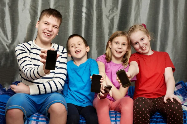 Happy children show mobile phones — Stock Photo, Image