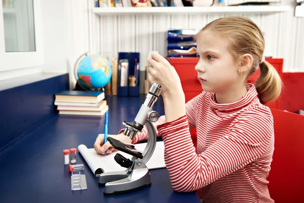 Menina examina droga para o microscópio — Fotografia de Stock