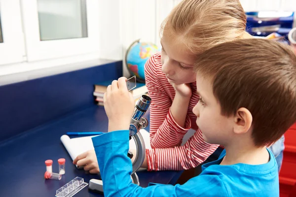 Chica y niño examina la droga para microscopio —  Fotos de Stock