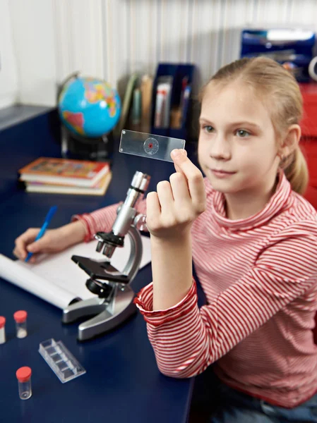 Dziewczyna bada lek pod kątem mikroskopu. — Zdjęcie stockowe