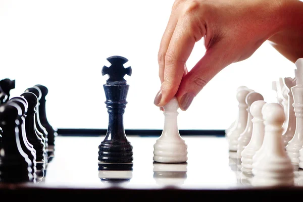 Hand with white pawn moves to black king — Stock Photo, Image