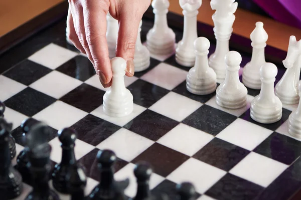 Hand mit weißem Bauern auf Schachbrett — Stockfoto