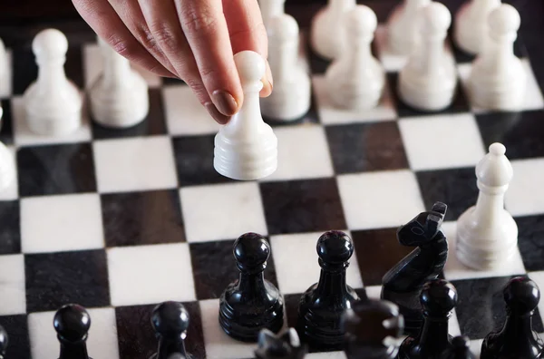 Hand with white pawn over chessboard — Stock Photo, Image