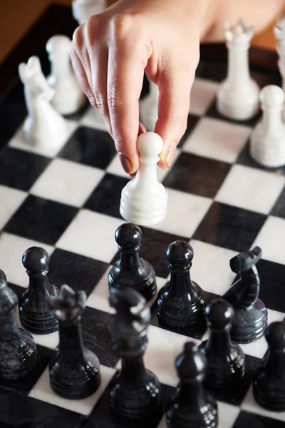 Mão com peão branco sobre tabuleiro de xadrez — Fotografia de Stock