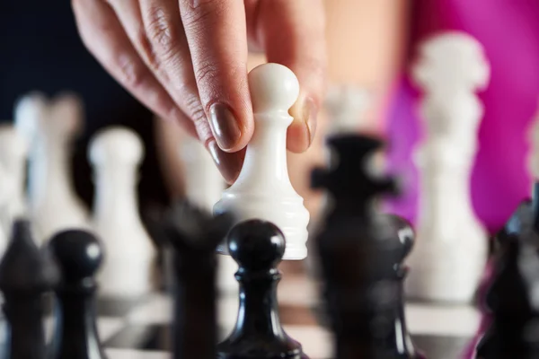 Hand with white pawn over chessboard — Stock Photo, Image