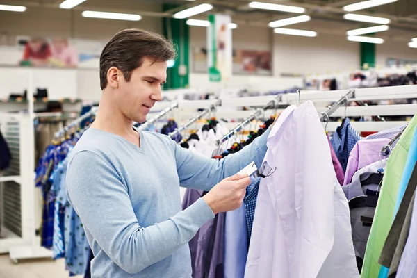 Man op zoek naar prijskaartje van goederen — Stockfoto