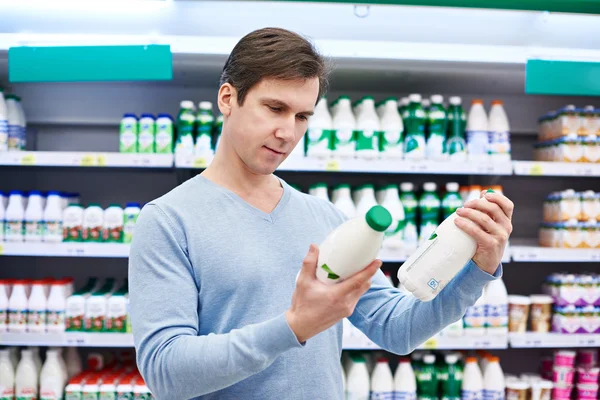 Man chooses dairy products in store — Stock Photo, Image