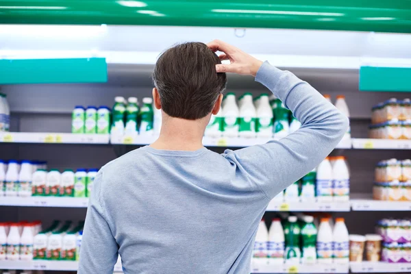 Man chooses dairy products in store Stock Image