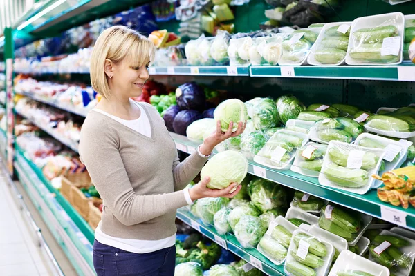 Woman buys white cabbage in store — Stock Photo, Image