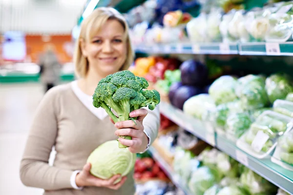 Donna felice mostrando broccoli — Foto Stock
