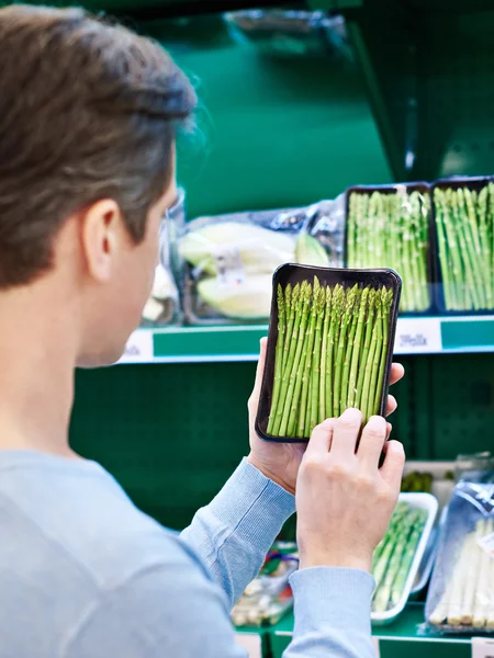 L'uomo compra un asparago in negozio — Foto Stock