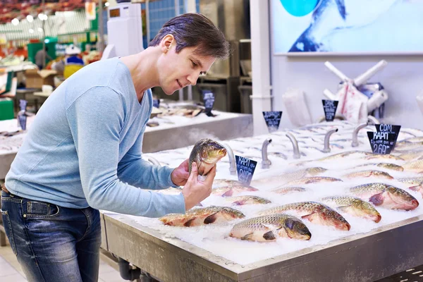 L'uomo sceglie il pesce carpa nel supermercato — Foto Stock