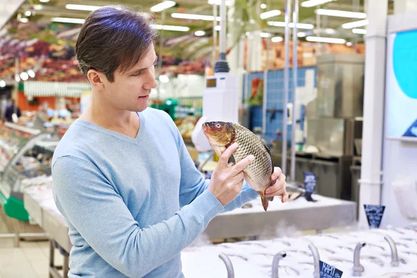 L'uomo sceglie il pesce carpa nel supermercato — Foto Stock