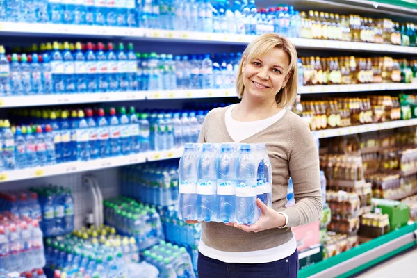 Mulher com embalagem de água potável — Fotografia de Stock