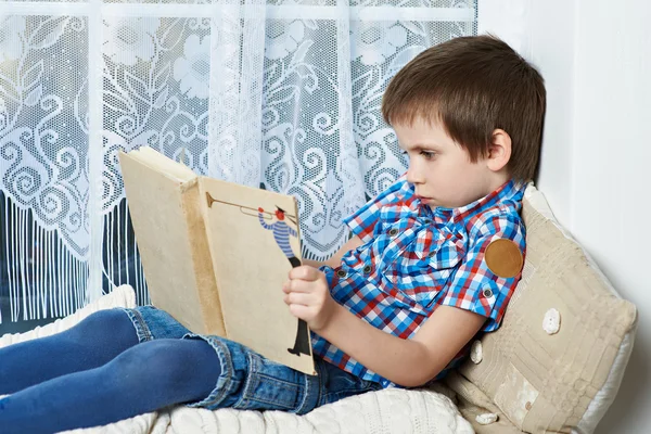 Liten pojke läser bok — Stockfoto