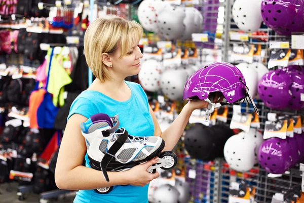 Menina escolhe capacete para patinação em rolo — Fotografia de Stock