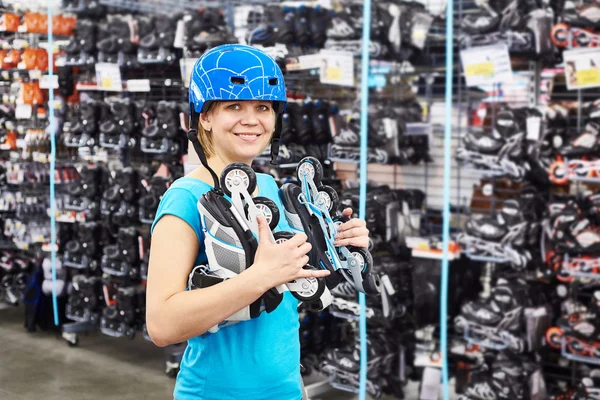 女孩在头盔和滚子在体育用品商店 — 图库照片