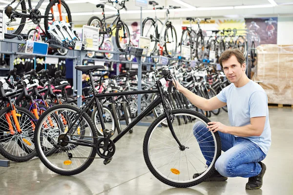 Homem verifica bicicleta antes de comprar na loja de esporte — Fotografia de Stock