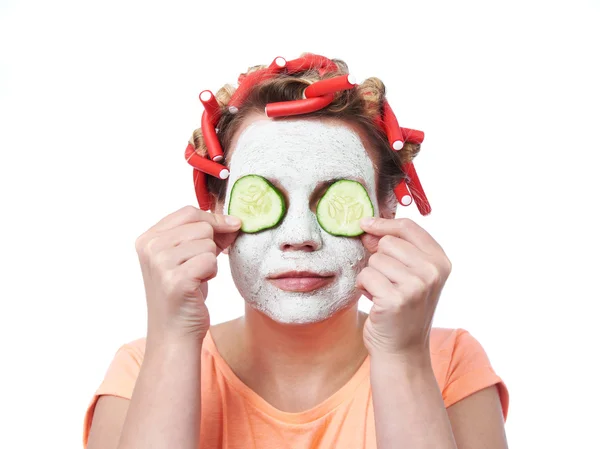 Young woman in curlers and with a mask on her face — Stock Photo, Image