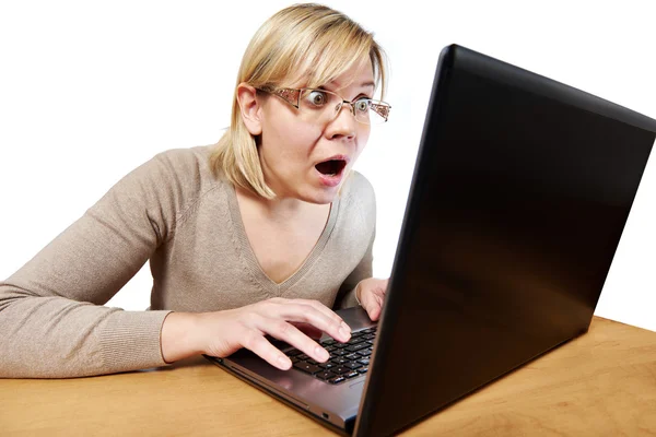 Frightened woman with glasses looking at laptop — Stock Photo, Image