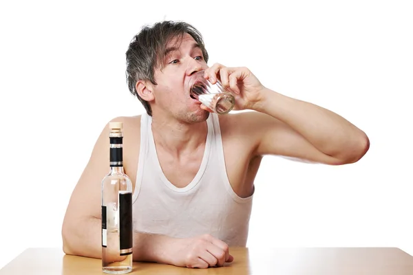 Drunk man drinks a glass of vodka — Stock Photo, Image