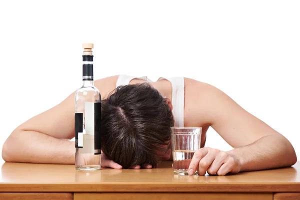 Dronken mens in slaap aan tafel met glas wodka — Stockfoto