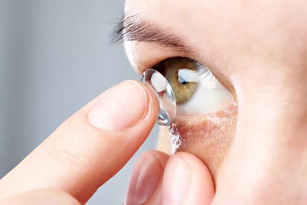 Vrouw zet contactlenzen — Stockfoto