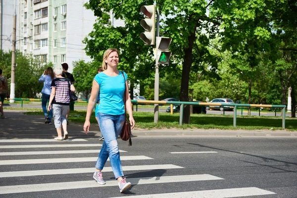 Молодая женщина переходит дорогу на зеленом свете — стоковое фото