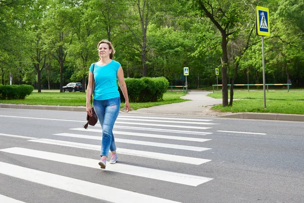 Giovane donna che attraversa la strada — Foto Stock