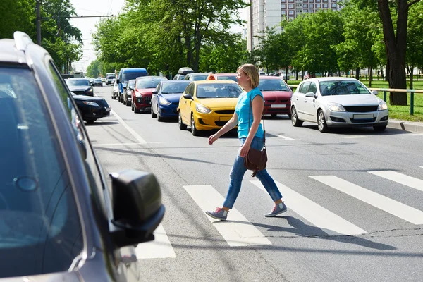 Woman crossing street at pedestrian crossing — Stock Photo, Image