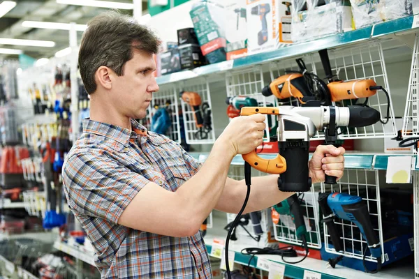 Man shopping for perforator in hardware store — Stock Photo, Image