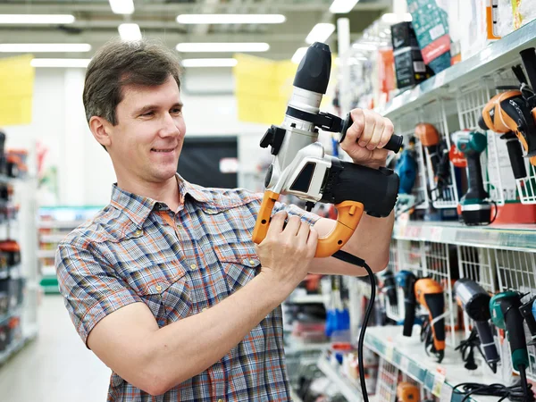 Man shopping for perforator in hardware store — 스톡 사진