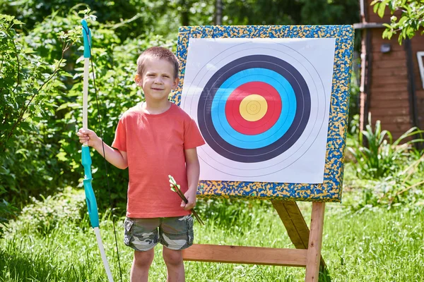 Kleine jongen met grote boog in de buurt van sport gericht — Stockfoto