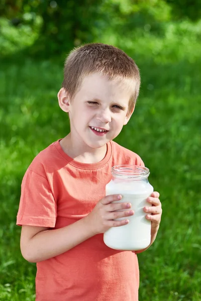 Junge mit Milchkrug im sonnigen Garten — Stockfoto