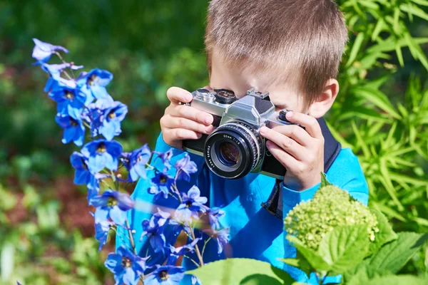 Niño con cámara SLR retro disparando macro flores — Foto de Stock