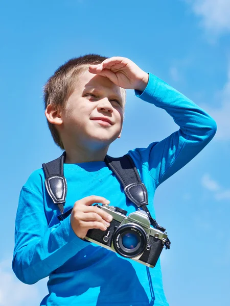 Niño pequeño con cámara retro en el cielo mira a la distancia —  Fotos de Stock