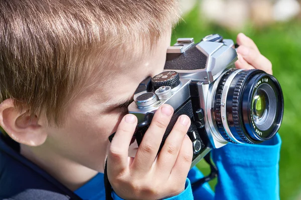 Niño pequeño con cámara retro de disparo — Foto de Stock