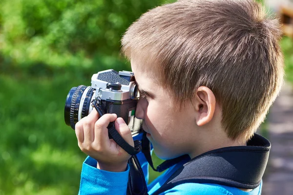 Niño pequeño con cámara retro de disparo — Foto de Stock