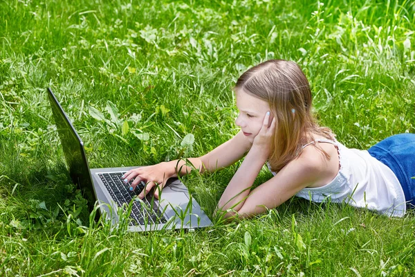 Girl using laptop on grass — Stock Photo, Image