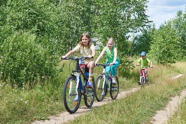 Crianças felizes em passeio de bicicleta na estrada rural — Fotografia de Stock