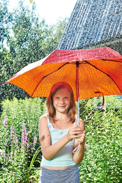 Glückliches Mädchen mit rotem Regenschirm im Regen — Stockfoto