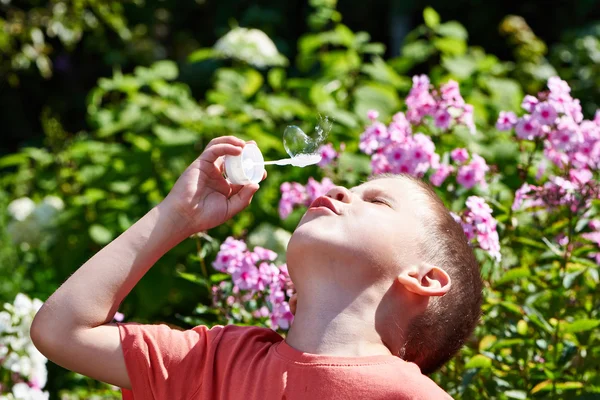 Kleiner Junge pustet Seifenblasen — Stockfoto