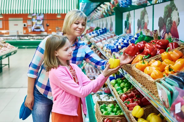 Мать и дочь выбирают перец в супермаркете — стоковое фото