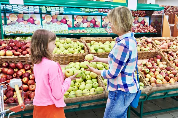 Moeder en dochter kiest appels in supermarkt — Stockfoto